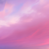 Soft pink and purple clouds drifting across a pastel sky with no visible product or packaging.